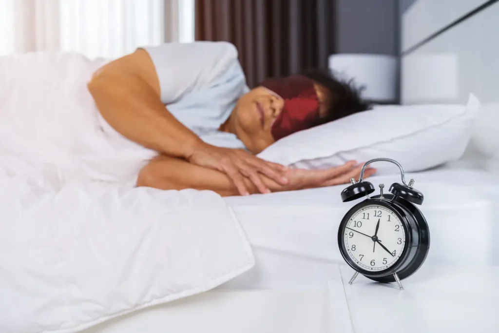 ผู้สูงอายุนอนปิดตา มีนาฬิกาปลุกข้างเตียง